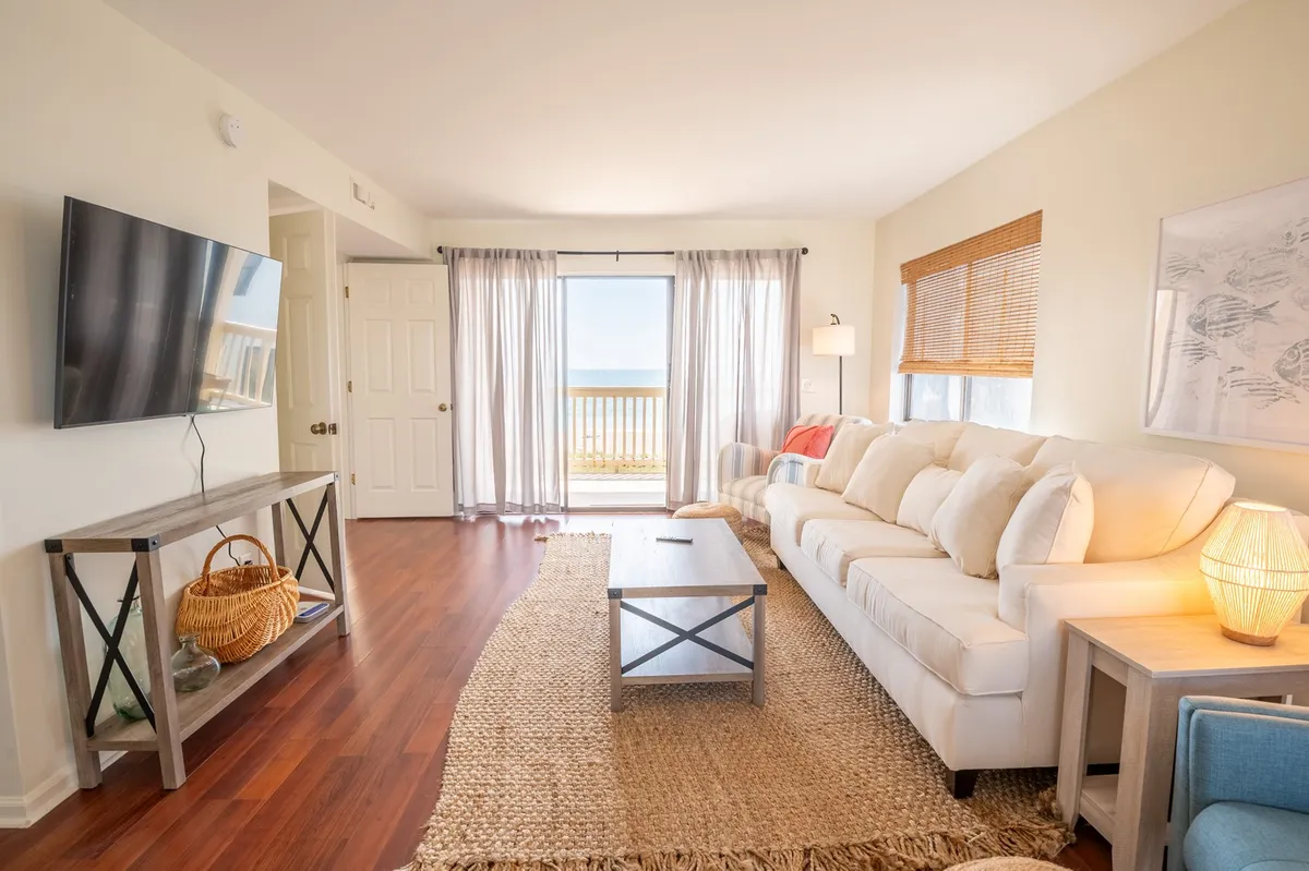 A bright and open living area features a comfortable sofa and coffee table, with large windows offering views outside. The space is designed for relaxing, socializing, and entertaining guests, inviting small groups to gather and unwind after a day of exploration.